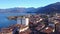 Drone backward. Aerial view of Lake Iseo, lakeshore, dock, and Italian town