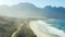 Drone, beach and mountain with waves for travel in summer with scenery, adventure and tropical location. Aerial view