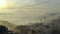 Drone, buildings and city in fog, sea and sunrise in clouds with landscape, skyline and horizon. Metro landscape