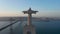Drone camera ascending along pedestal and statue. Evening back view of Christ the King Sanctuary in Almada. Long cable