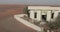 A drone captures camels near a minaret in a sand-covered desert city