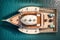 A drone captures the view of a wooden deck yacht docked in the Aegean Sea from above. AI