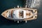 A drone captures the view of a wooden deck yacht docked in the Aegean Sea from above. AI