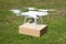 Drone carrying parcel over grassy field