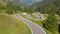 DRONE Cars and recreational vehicle driving through green landscape of Dolomites