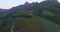 Drone, countryside and landscape of farm, nature and mountains by blue sky in Italy. Aerial view, agriculture and forest