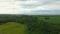 Drone crane shot, rising gently above the trees and fields revealing the magnificent landscape of Petite Matane with the St-