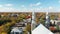 Drone crane video from behind the church in St-Eustache, on a bright Fall day, revealing the old St-Eustache with colorful trees