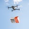 Drone delivering a coronavirus home test kit to residential area against blue sky