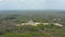 Drone descending and orbiting around historic settlement. Aerial view of landmarks and vast forest. Historical monuments