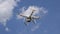 Drone DJI Phantom 4 in flight. Quadrocopter against the blue sky with white clouds. The flight of the copter in the sky.