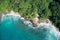 Drone field of view of secret cove with turquoise blue water meeting the forest on secluded island of Mahe, Seychelles