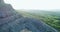 A drone flies aerial view around a rock peak