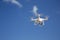 Drone flies against blue sky on sunny day