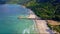 Drone Flies along Azure Sea to Sand Beach by Green Hills