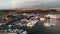 Drone flies through beautiful tourist quay with yachts and boats at city harbor. Aerial view of Cyprus island with lighthouse and