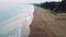 Drone flies at dusk over Mediterranean, capturing beach, wave, in Mersin, Turkey. Aerial view showcases beach, wave