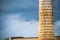 The drone flies near the ruins and the high water tower. Against the background of the summer sky with clouds