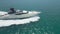 A drone flies over an expensive private yacht sailing on a calm sea against the backdrop of Dubai's skyscrapers