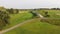 A drone flies over a green golf course with building