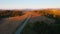 Drone flies over a road that runs through a coniferous forest in light of sunset. Filmed in 4k, drone video