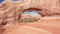 Drone Flies Through Red Orange Stone Arch With Massive Rock Formations In Utah