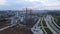 The drone flies towards the construction site. Unfinished houses and tower cranes are visible. Multi-storey urban development