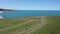 Drone flight above a girl at picturesque coastline