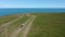 Drone flight above a girl at picturesque coastline