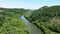 Drone flight above a river in green forest