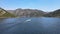 Drone flight behind a boat the river and mountains and forest on a sunny day