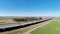 Drone Flight Over Grass Field With Blue Sky Near Freeway