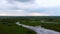 Drone flight over a winding shallow river.
