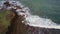 Drone flight view of waves crashing on the Mirissa Parrot Rock rocky coast.