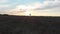 Drone fly by girl launching kite at sunset in picturesque field