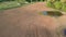 Drone fly high above spring farmland fields with water puddle and two beehive house on wheels