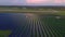 Drone fly over Solar Farm. Renewable green energy and electrical technology. Field of Solar Panels Stands in a Row in