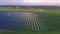 Drone fly over Solar Farm. Renewable green energy and electrical technology. Field of Solar Panels Stands in a Row in