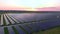 Drone fly over Solar Farm. Renewable green energy and electrical technology. Field of Solar Panels Stands in a Row in