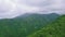 Drone fly over tropical mountains covered with forest and lush greenery.