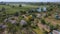 Drone fly over waving river of blue color surrounded by local village with various buildings and Wetland and marsh habitat with a