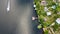 Drone fly over waving river of blue color surrounded by local village with various buildings and Wetland and marsh habitat with a