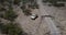 Drone flying above lonely abandoned vintage pickup truck near sandstone gravel desert road, lost in summer USA heat.