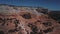 Drone flying away from tourist couple standing in famous Arches rock formation in sunny Arizona mountain national park.