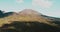 Drone flying forward to Vesuvius volcano, Italy. Birds eye view panorama of epic mountain forest with cloud shadows. 4K.