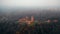 Drone flying high up around ancient Turaidas castle museum reserve in Sigulda national park foggy forest, Latvia.