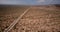 Drone flying left above beautiful desert road in amazing giant cactus field with car driving at Arizona national park.