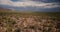 Drone flying low above atmospheric cactus desert field towards large sandstorm clouds at epic Arizona national park USA.