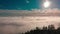 Drone flying over clouds and a mountain at sunset