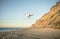 Drone flying over deserted fairy tale beach with golden sand, beautiful sky and turquoise water on the shores of ocean.